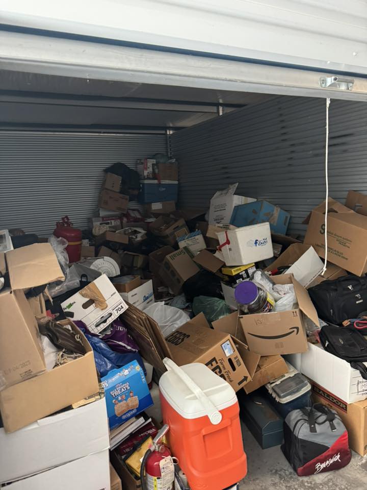 Packed storage unit filled with boxes and household items before Little Fellas Moving cleanout