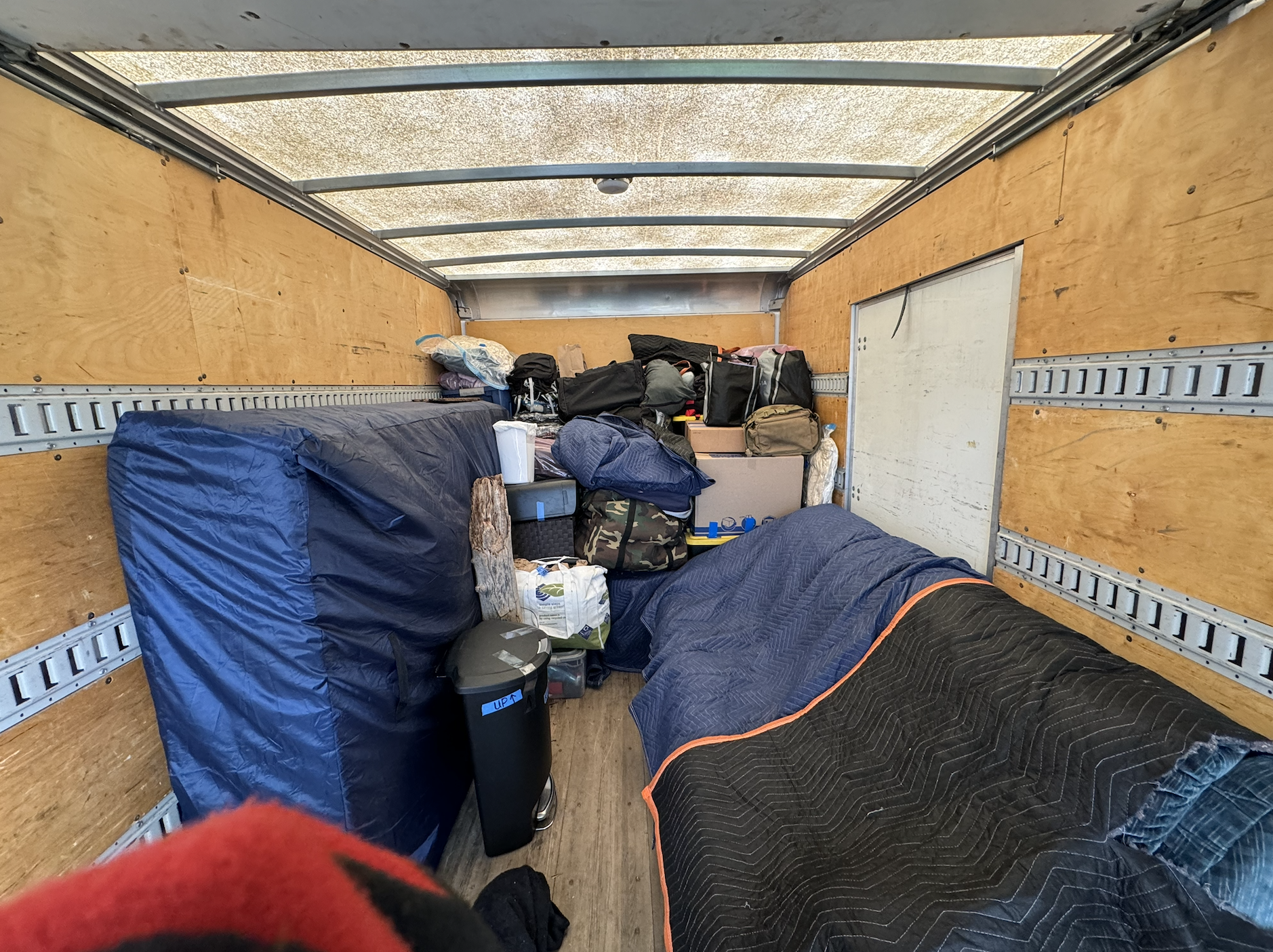Professional packing inside moving truck with organized boxes and moving blankets